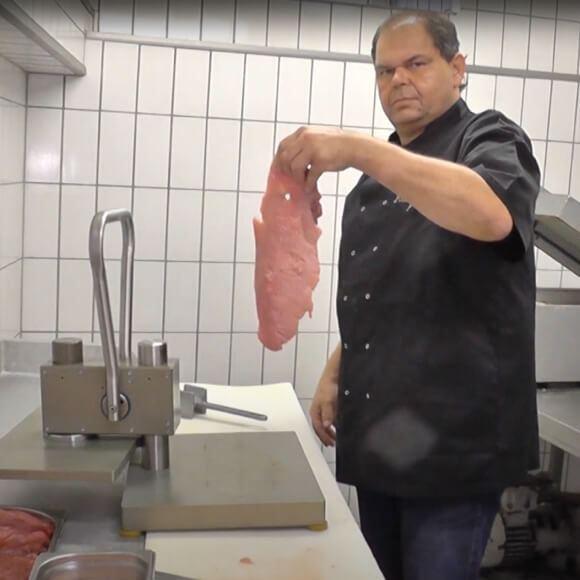 Person zeigt fertiges Fleisch